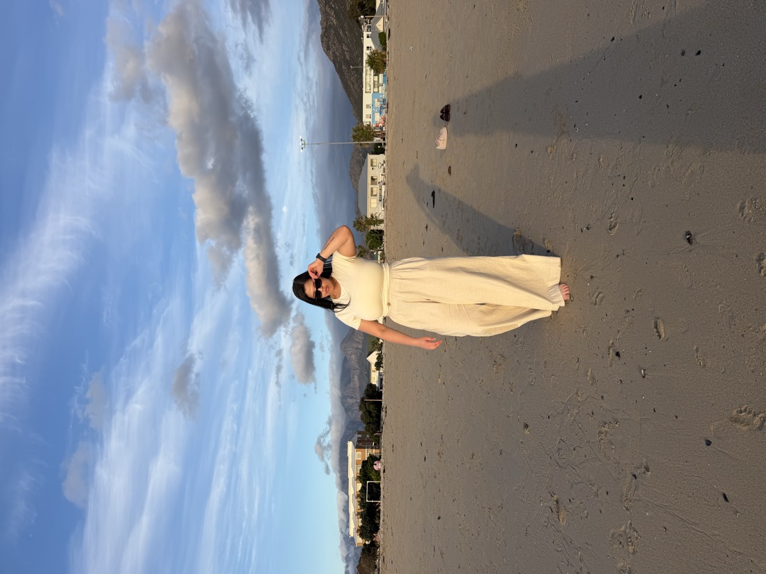 Teneille on a wide beach under a blue sky